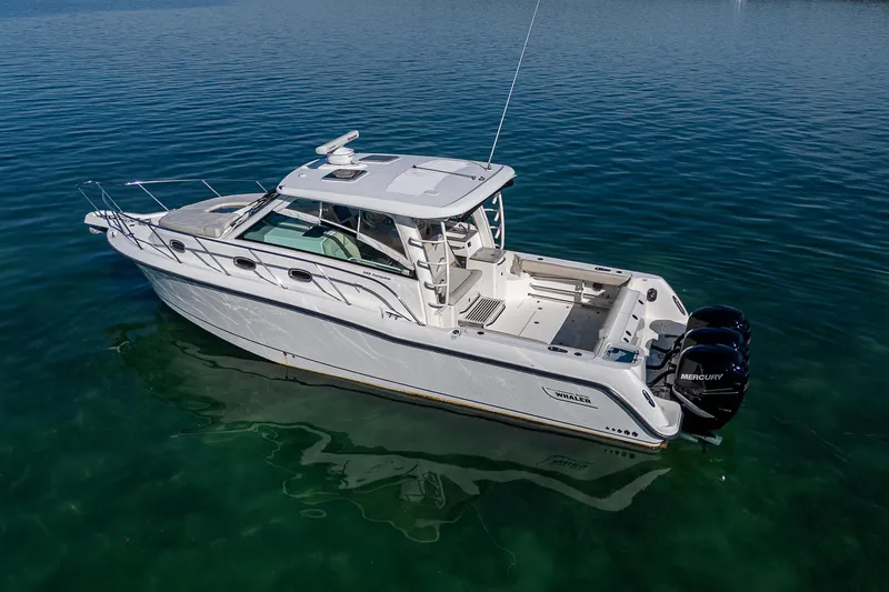  Yacht Photos Pics 2017 Boston Whaler 345 Conquest boat on calm water, featuring triple Mercury engines.