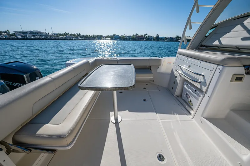  Yacht Photos Pics 2017 Boston Whaler 345 Conquest boat interior with seating and table on a sunny day.