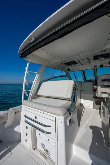  Yacht Photos Pics 2017 Boston Whaler 345 Conquest boat interior with seating and helm, under clear blue sky.