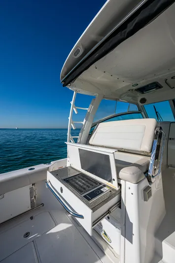 Yacht Photos Pics 2017 Boston Whaler 345 Conquest boat interior with seating and open storage, under clear blue sky.