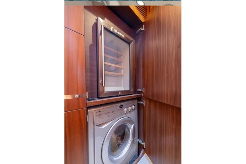  Yacht Photos Pics Luxury yacht interior with wood paneling, featuring a built-in wine cooler and washing machine.