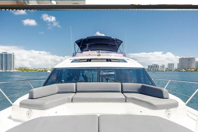  Yacht Photos Pics 2017 Princess S65 yacht with spacious deck, cruising on a sunny day with city skyline.