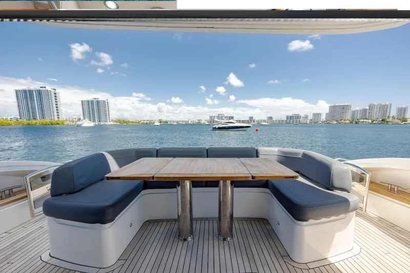  Yacht Photos Pics Luxurious 2017 Princess S65 yacht deck with seating, overlooking a scenic waterfront cityscape.