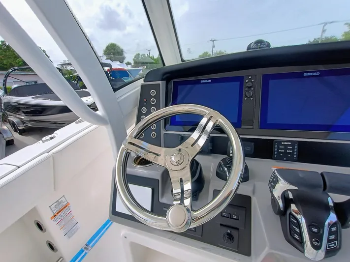 270-152 Yacht Photos Pics 2025 Robalo R270 Center Console boat dashboard with steering wheel and dual displays.