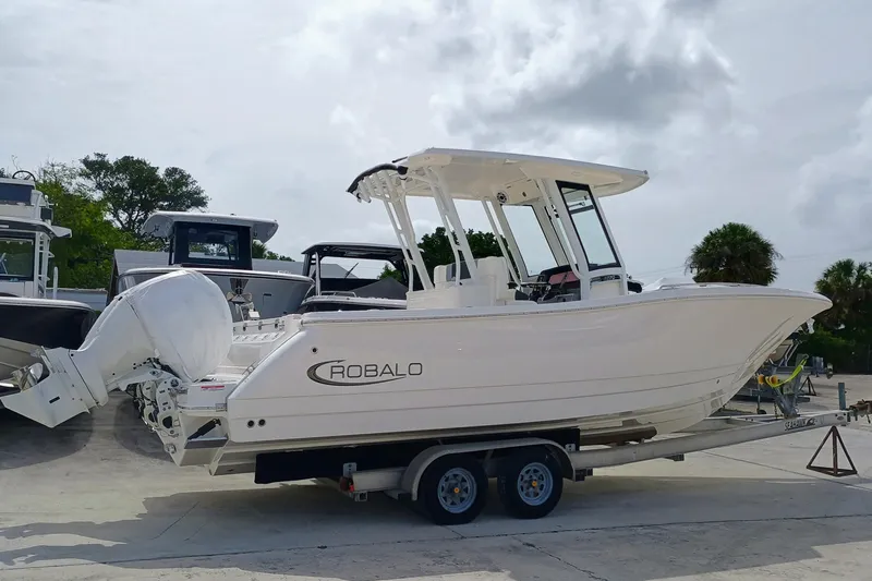 270-152 Yacht Photos Pics 2025 Robalo R270 Center Console boat on trailer, parked outdoors.