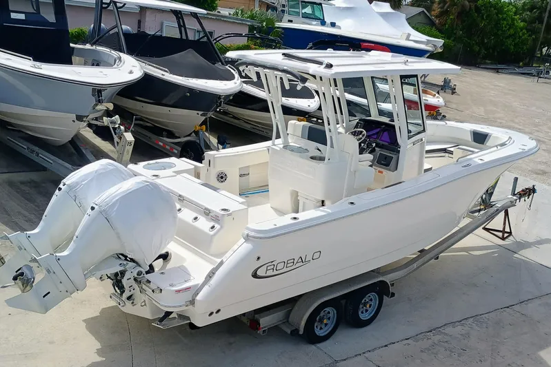 270-152 Yacht Photos Pics 2025 Robalo R270 Center Console boat on trailer, featuring dual engines.