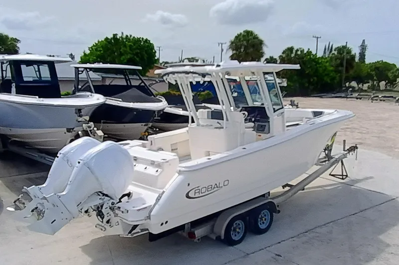 270-152 Yacht Photos Pics 2025 Robalo R270 Center Console boat on trailer, parked outdoors.
