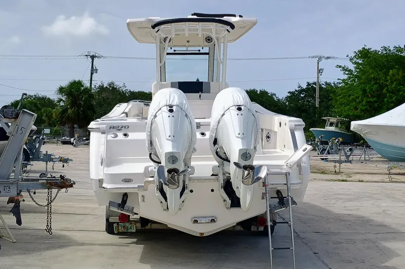 270-152 Yacht Photos Pics 2025 Robalo R270 Center Console boat with dual engines, parked on a trailer.