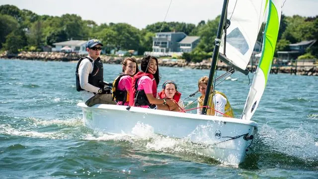 Group sailing on RS Quest 2025 boat in sunny coastal waters.