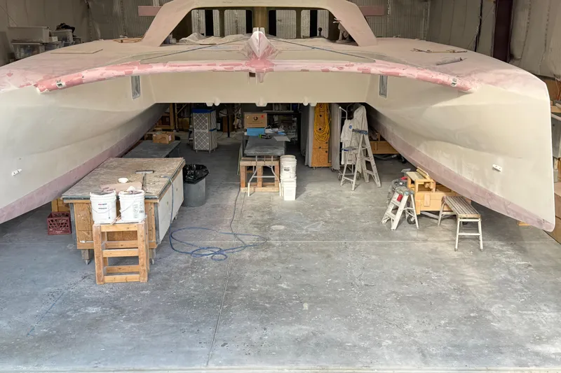  Yacht Photos Pics 2026 Schionning Arrow 1280 S catamaran under construction in a workshop.