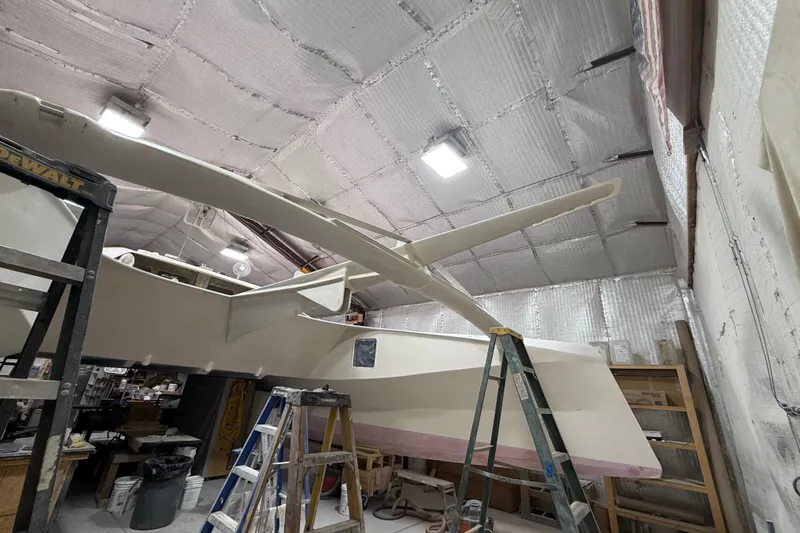  Yacht Photos Pics 2026 Schionning Arrow 1280 S catamaran under construction in a workshop.