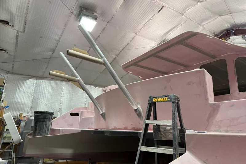  Yacht Photos Pics 2026 Schionning Arrow 1280 S catamaran under construction in a workshop.