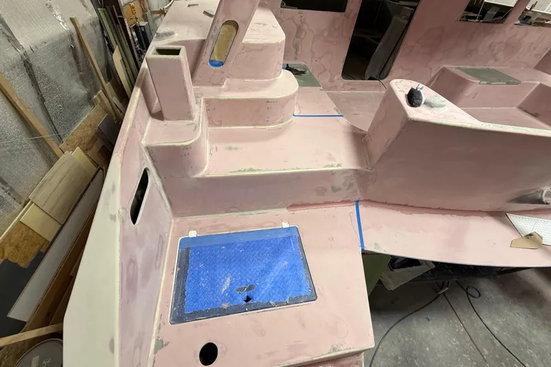  Yacht Photos Pics 2026 Schionning Arrow 1280 S catamaran under construction, showcasing unfinished deck details.