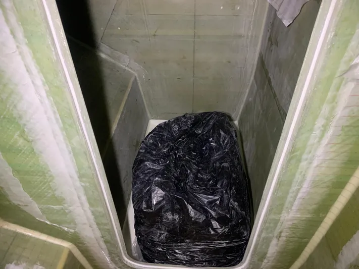  Yacht Photos Pics Interior compartment of 2024 Schionning Arrow 1280 S with a black plastic-wrapped item.