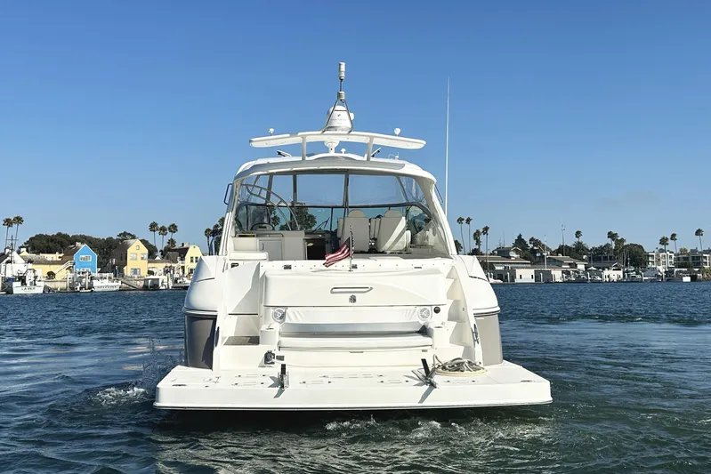  Yacht Photos Pics 2007 Cruisers Yachts 540 Express on water, with coastal houses in background.
