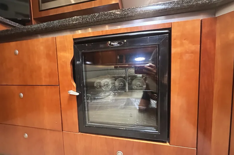  Yacht Photos Pics 2007 Cruisers Yachts 540 Express interior with built-in mini fridge and wooden cabinetry.