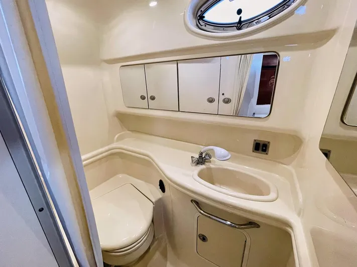  Yacht Photos Pics 2005 Sea Ray 340 Sundancer bathroom with sink, toilet, and mirrored cabinet.