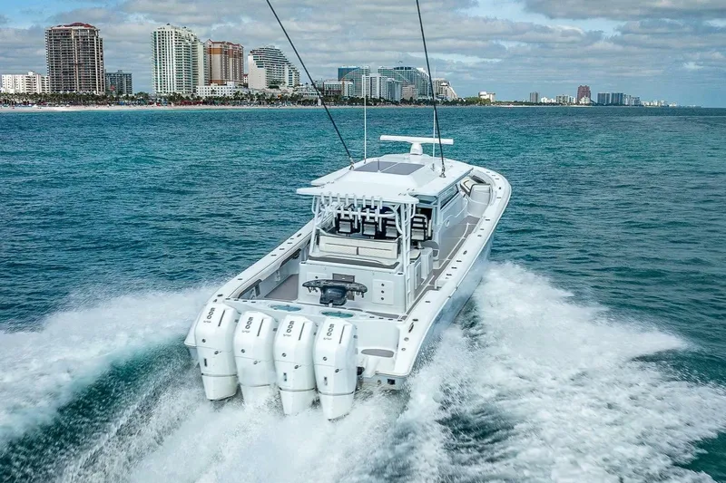  Yacht Photos Pics 2024 Yellowfin 54 Offshore boat cruising near city skyline on open water.