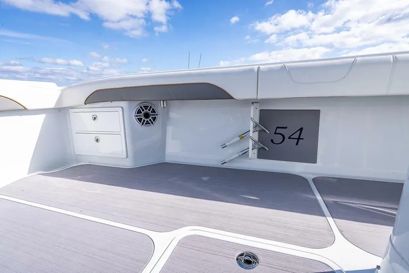  Yacht Photos Pics 2024 Yellowfin 54 Offshore boat deck with storage and speaker, under clear blue sky.