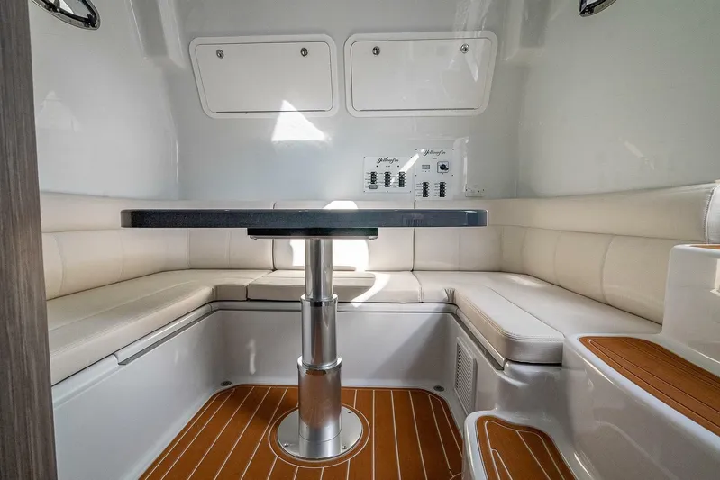  Yacht Photos Pics 2024 Yellowfin 54 Offshore interior with cushioned seating and sleek table design.