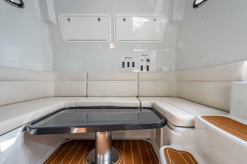  Yacht Photos Pics 2024 Yellowfin 54 Offshore interior with white seating and sleek table design.
