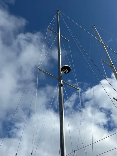 Royal Dawn Yacht Photos Pics Tall mast of a 2001 Hunter 460 sailboat against a cloudy blue sky.