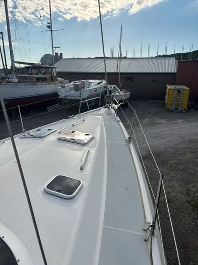 Royal Dawn Yacht Photos Pics Sailboat deck view, Hunter 460, 2001 model, docked near other boats under a cloudy sky.
