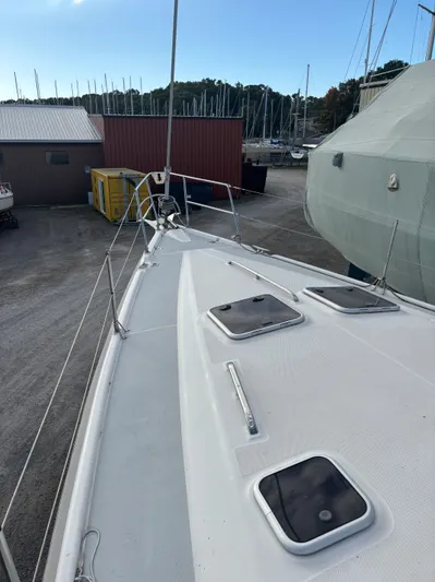 Royal Dawn Yacht Photos Pics 2001 Hunter 460 sailboat deck in a marina, surrounded by other boats and buildings.
