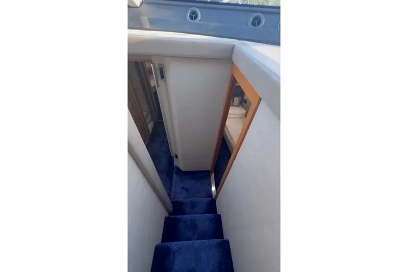  Yacht Photos Pics Interior staircase of 2014 Azimut 70 yacht with blue carpet and wooden accents.