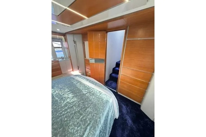  Yacht Photos Pics Luxurious bedroom interior of 2014 Azimut 70 yacht with modern wood paneling.