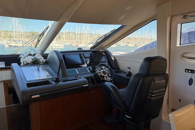 Thomas Yacht Photos Pics Interior helm of 2012 Sunseeker Manhattan 63 yacht with modern controls and leather seating.