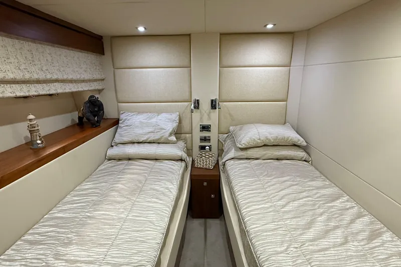 Thomas Yacht Photos Pics Twin cabin interior of 2012 Sunseeker Manhattan 63 yacht, featuring modern decor and cozy beds.