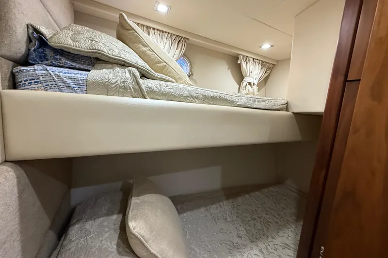 Thomas Yacht Photos Pics Bunk beds in 2012 Sunseeker Manhattan 63 yacht cabin, featuring cozy bedding and elegant curtains.