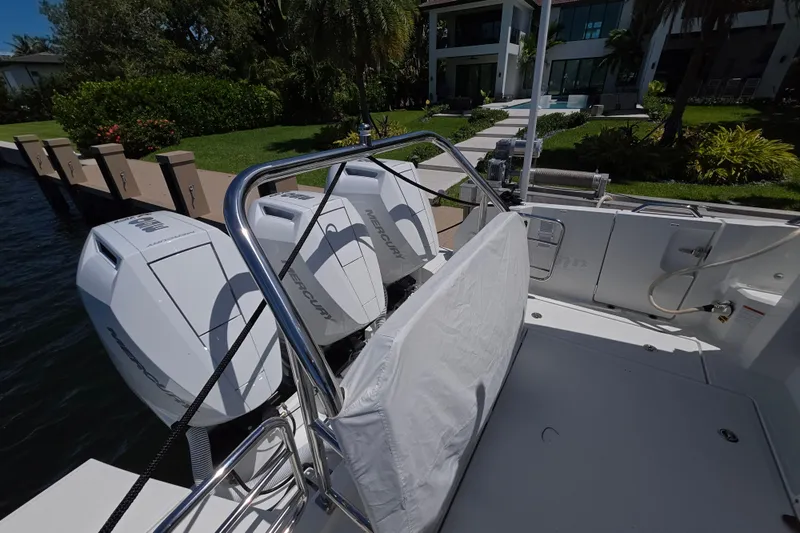  Yacht Photos Pics 2024 Wellcraft 355 Commuter boat with Mercury engines docked by a waterfront property.