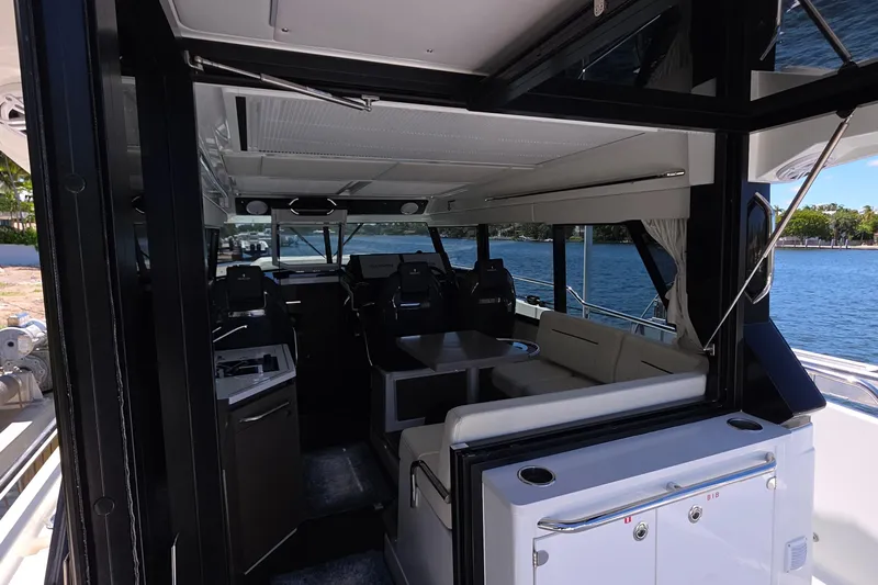  Yacht Photos Pics 2024 Wellcraft 355 Commuter interior with seating and helm, docked by the water.