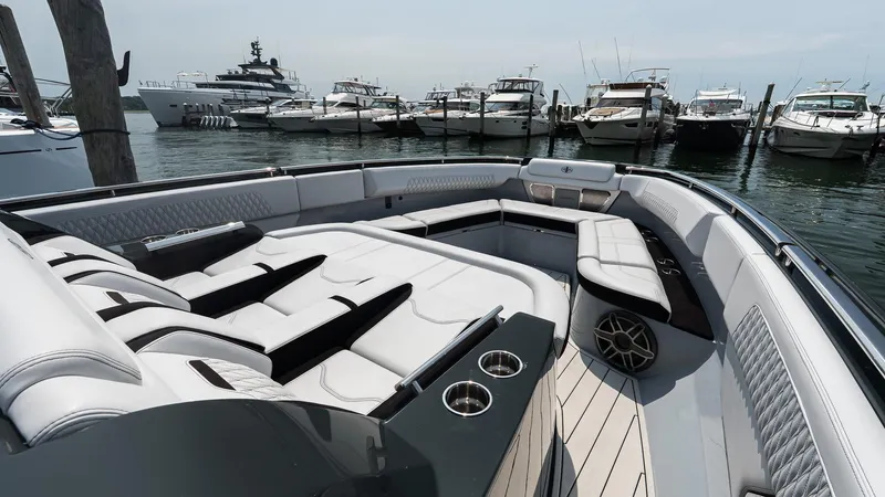  Yacht Photos Pics Luxurious 2025 Cigarette 52 Thunder yacht interior with plush seating, docked among other boats.