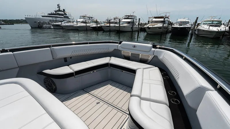  Yacht Photos Pics Luxurious 2025 Cigarette 52 Thunder boat interior with sleek seating, docked near yachts.