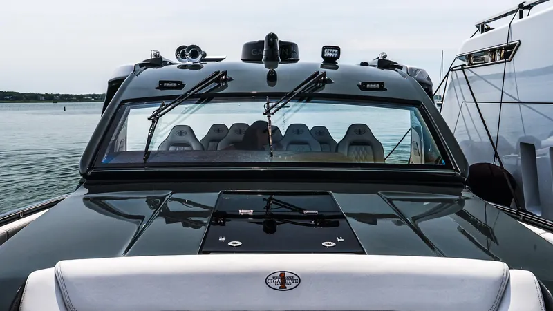  Yacht Photos Pics 2025 Cigarette 52 Thunder boat, sleek design, luxury seating, docked on calm water.