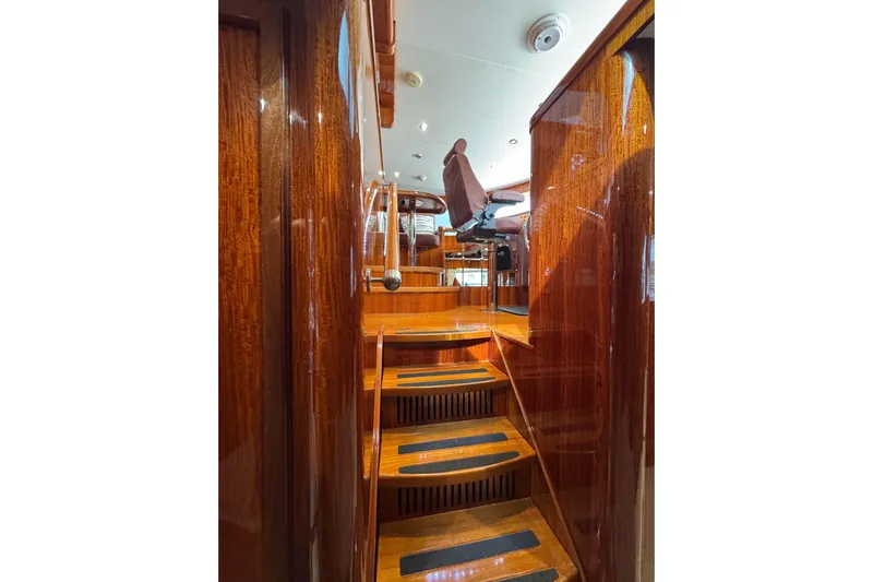 Aleniel Yacht Photos Pics Interior of 2005 Johnson 87' Motor Yacht with polished wooden stairs and seating.