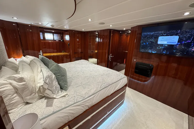 Aleniel Yacht Photos Pics Luxurious bedroom interior of 2005 Johnson 87' Motor Yacht with wood paneling and modern amenities.