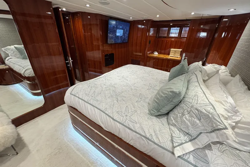 Aleniel Yacht Photos Pics Luxurious bedroom interior of 2005 Johnson 87' Motor Yacht with elegant wood paneling.