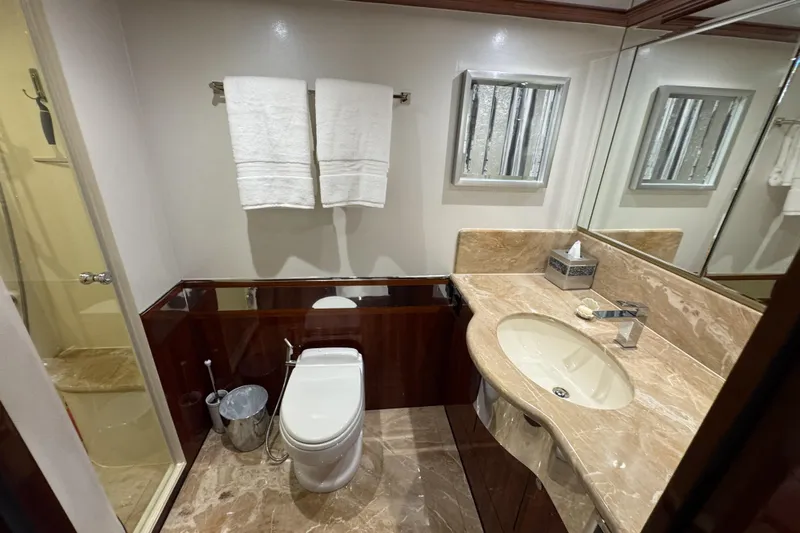Aleniel Yacht Photos Pics Luxurious bathroom in 2005 Johnson 87' Motor Yacht with marble countertop and modern fixtures.