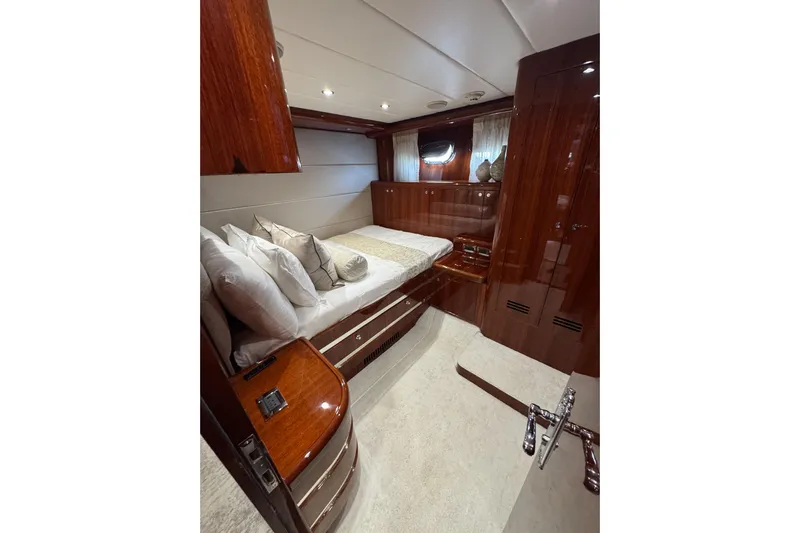 Aleniel Yacht Photos Pics Luxurious bedroom interior of 2005 Johnson 87' Motor Yacht with polished wood finish.