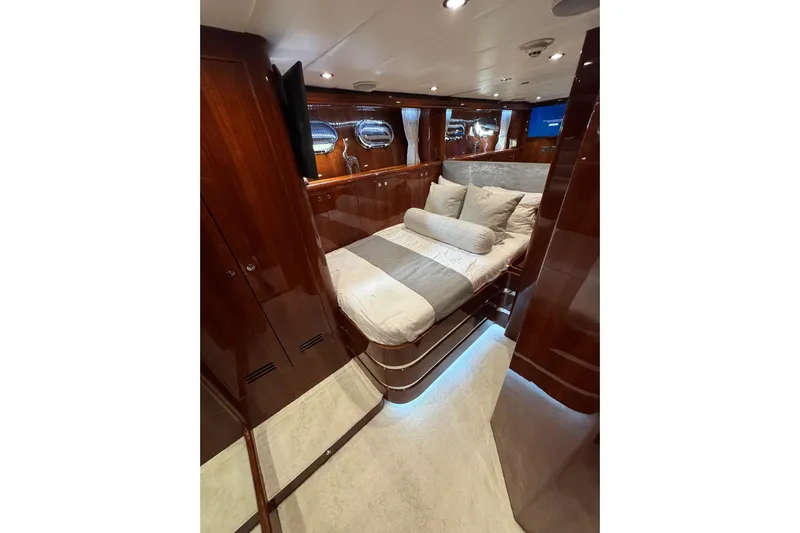Aleniel Yacht Photos Pics Luxurious bedroom interior of 2005 Johnson 87' Motor Yacht with elegant wood finishes.