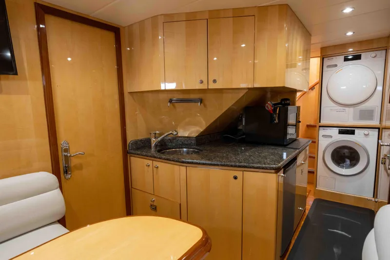 Aleniel Yacht Photos Pics Luxurious 2005 Johnson 87' Motor Yacht interior with modern kitchen and laundry appliances.