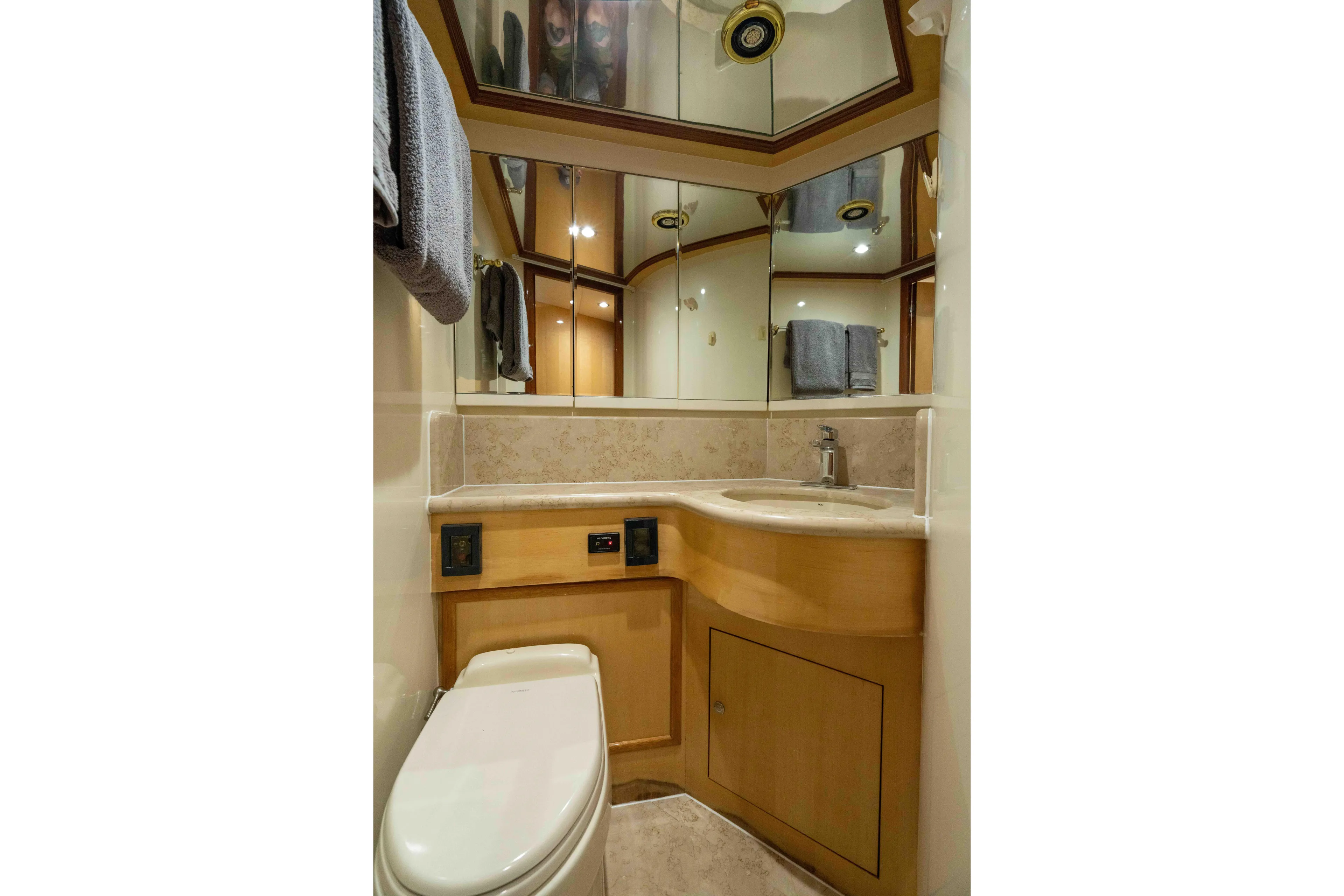 Aleniel Yacht Photos Pics Luxurious bathroom in 2005 Johnson 87' Motor Yacht with elegant wood cabinetry and mirrored walls.
