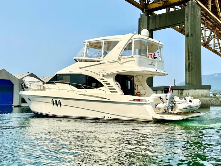 Hippeace Yacht Photos Pics 2009 Silverton Ovation 52 yacht docked under a bridge, featuring sleek design and luxury amenities.