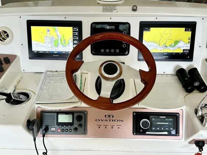 Hippeace Yacht Photos Pics 2009 Silverton Ovation 52 helm with navigation screens, wooden steering wheel, and control panel.