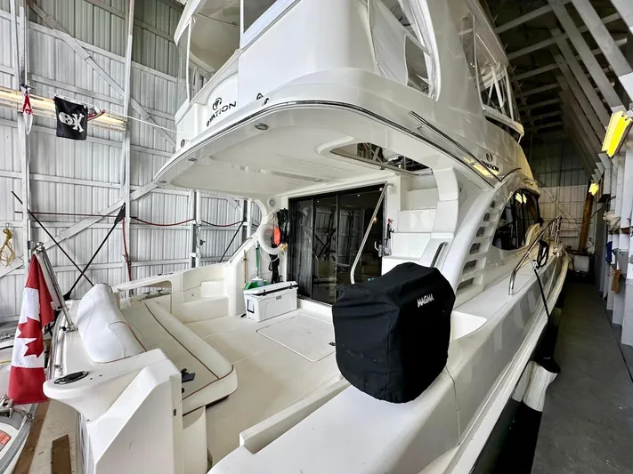 Hippeace Yacht Photos Pics 2009 Silverton Ovation 52 yacht in a boat shed, featuring spacious deck and Canadian flag.