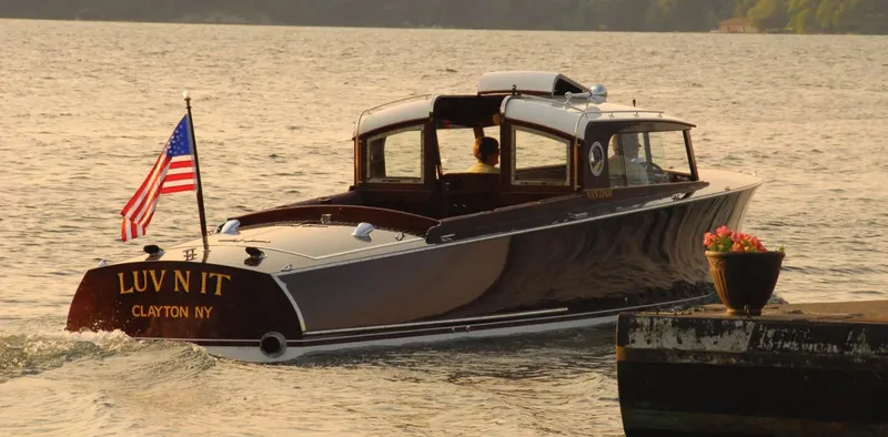 Luv N It Yacht Photos Pics Elegant 2015 Van Dam 35 boat on water, American flag, dockside flowers, sunset backdrop.